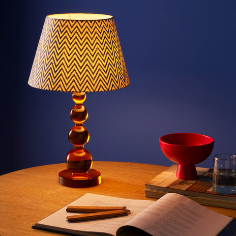 a orange resin rechargeable table lamp on a desk